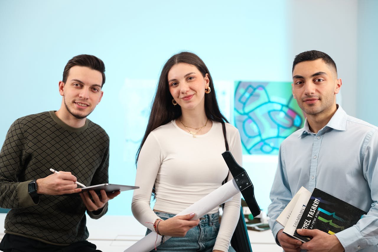 Three young adults discussing and collaborating in a modern office setting.